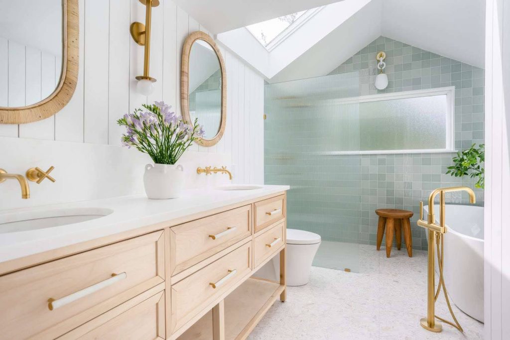 Spa-style bathroom with gold fixtures and freestanding tub by a top Bathroom Renovation Contractor on Long Island, NY.