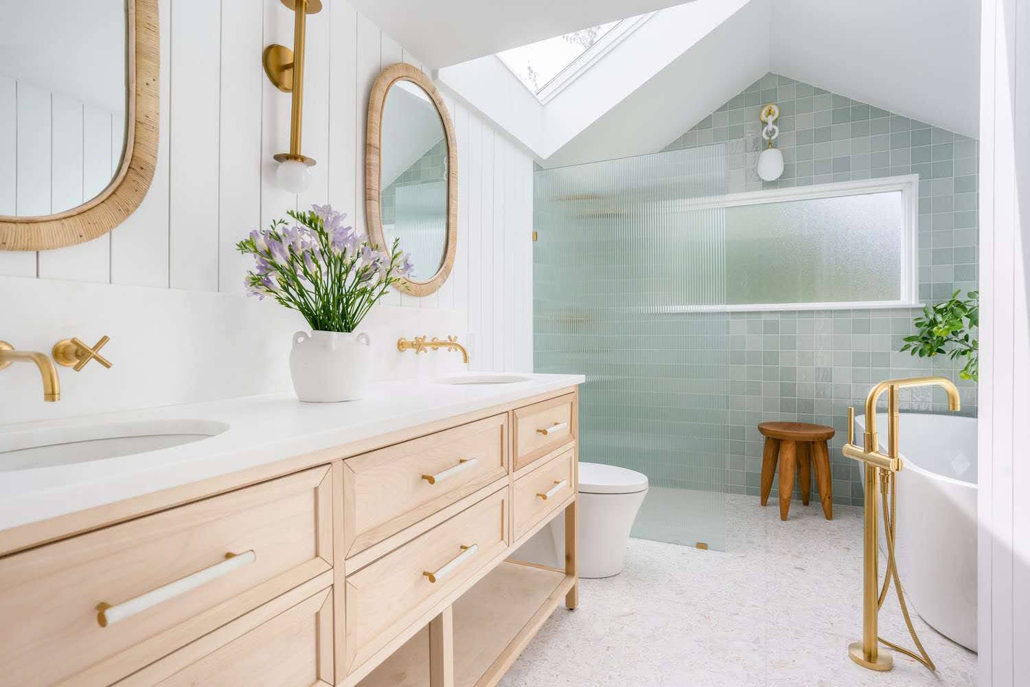 Spa-style bathroom with gold fixtures and freestanding tub by a top Bathroom Renovation Contractor on Long Island, NY.