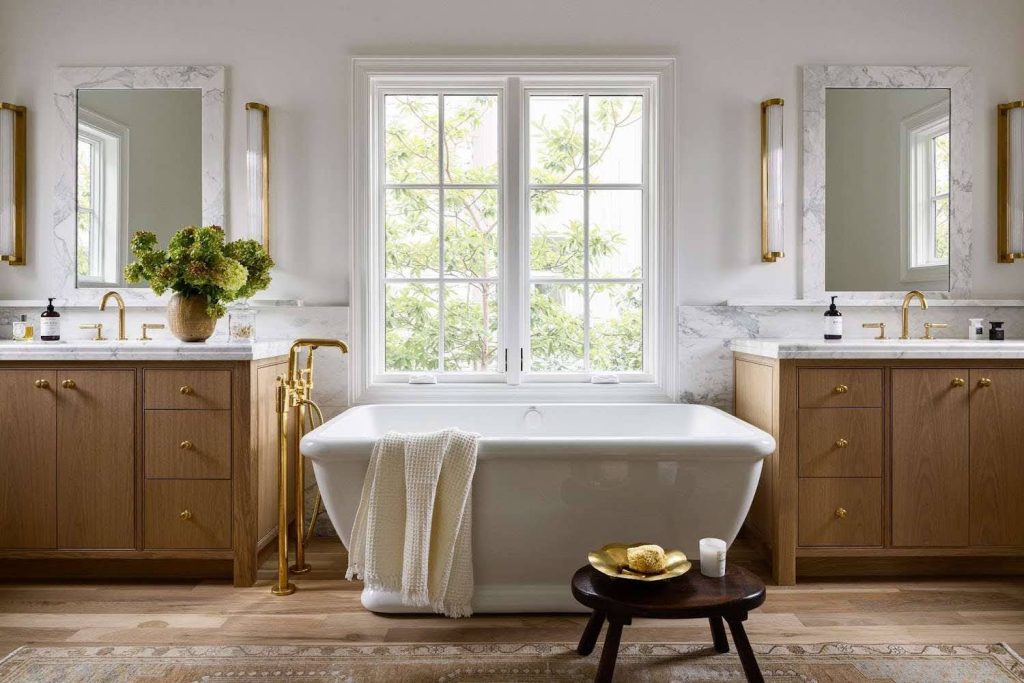 Light, Scandinavian-inspired bathroom with wood vanity and gold fittings from a trusted Bathroom Renovation Contractor.