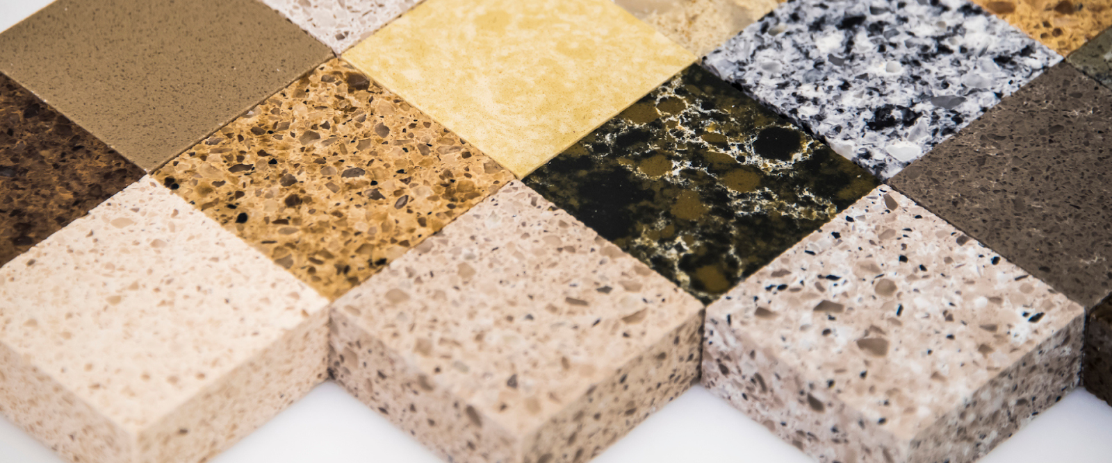 A selection of square countertop samples in various colors and textures arranged in a grid pattern.